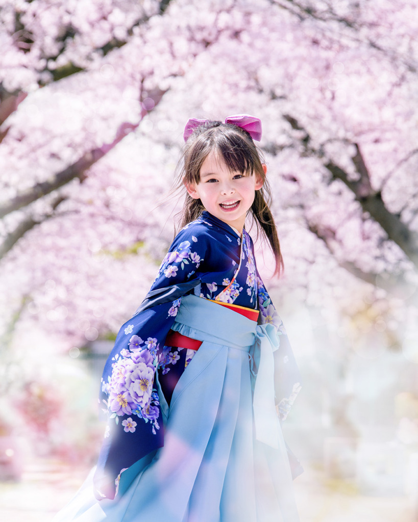 桜の下で微笑む袴の少女