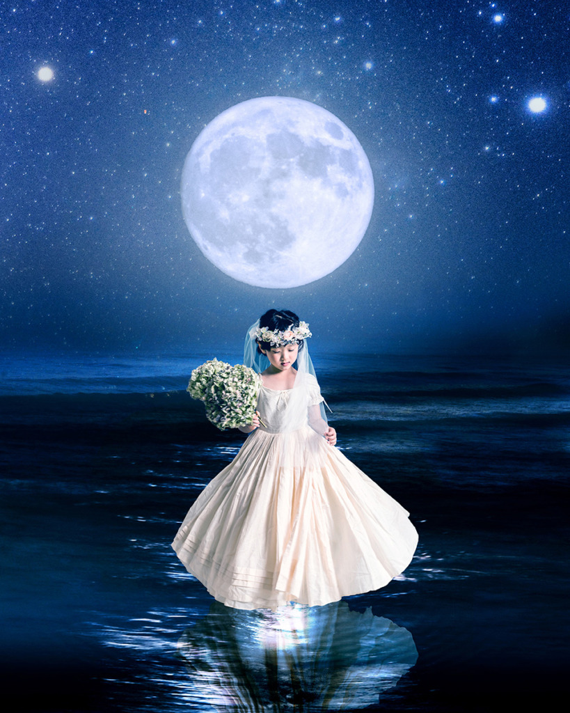 魔法現像を施した月を背に海にいるドレスの女の子